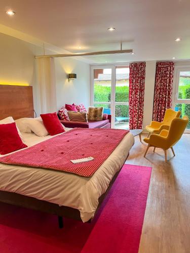 une chambre avec un grand lit avec une couverture rouge dans l'établissement Hotel Les Vallées Labellemontagne, à La Bresse