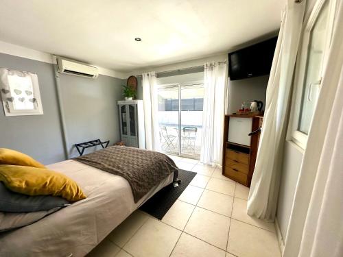 une chambre avec un lit, une fenêtre et une télévision dans l'établissement Chambre indépendante Villa Carpe Diem, à Mouans-Sartoux