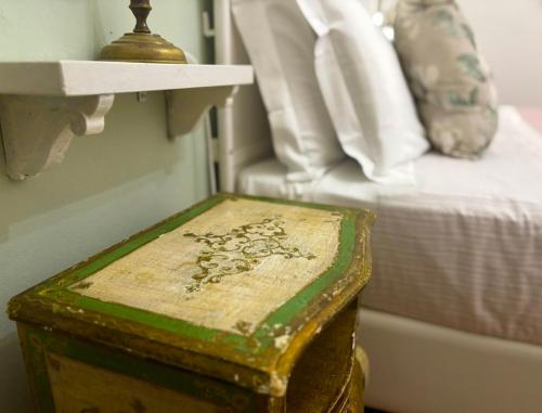 a wooden box sitting next to a bed at B&B La Fontanina in Siena
