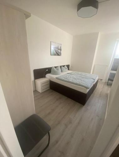 a bedroom with a bed and a chair at Ferienwohnungen Am Yachthafen in Greifswald