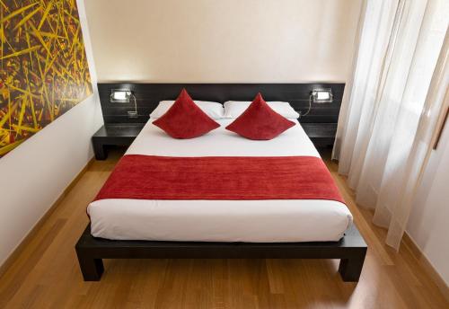 a bedroom with a bed with red pillows on it at Ca' Pozzo Inn in Venice