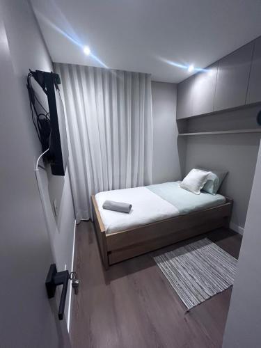 a small bedroom with a bed and a television at Puesta de Sol! Apartamento in Villavicencio