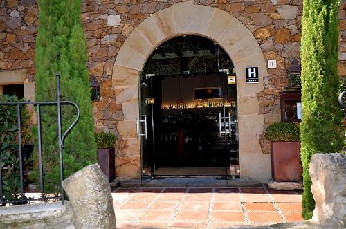an entrance to a building with an arched doorway at Hotel Galena Mas Comangau in Begur