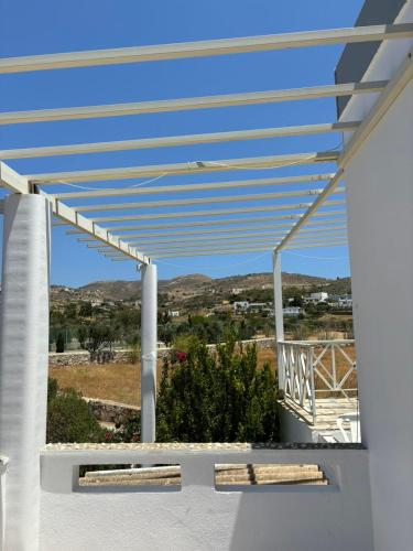 awning on a white house with a view of the mountains at Syros Rooms & Apartments in Posidhonía