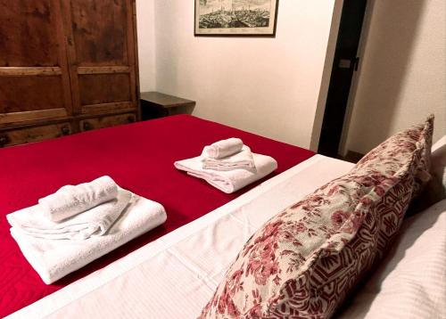 a bed with two towels sitting on top of it at B&B La Fontanina in Siena
