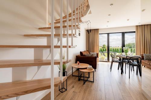 a living room and dining room with a spiral staircase at Klimat Tu - Stylowe Domki blisko Morza - Sarbinowo in Sarbinowo