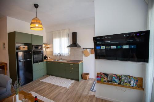 a kitchen with green cabinets and a black refrigerator at V la vie in Ioannina