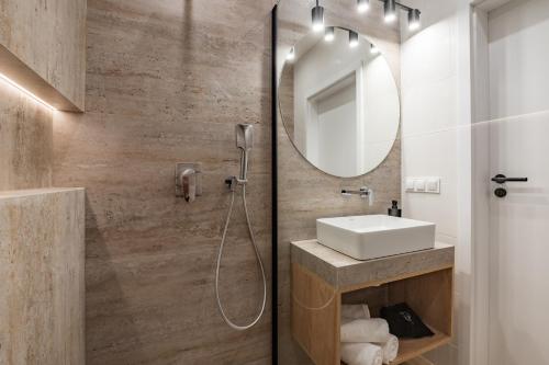 a bathroom with a sink and a mirror at Klimat Tu - Stylowe Domki blisko Morza - Sarbinowo in Sarbinowo