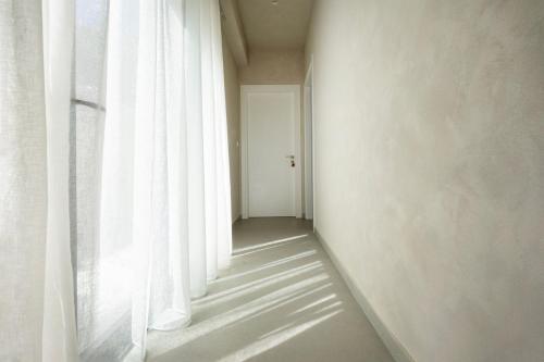 an empty hallway with a window with white curtains at Elithos Villa in Vryses