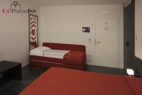 a room with two beds and a red couch at Ca' Pozzo Inn in Venice