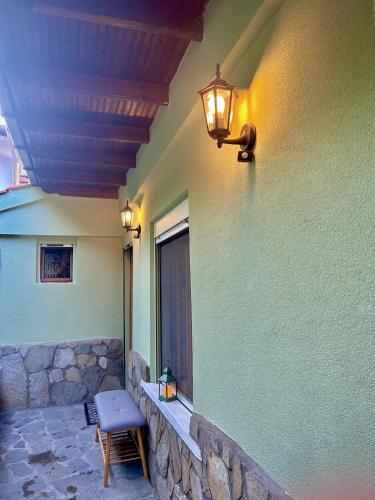 a lamp on a wall with a chair and a window at Daisy House Golden Beach Area in Potamia