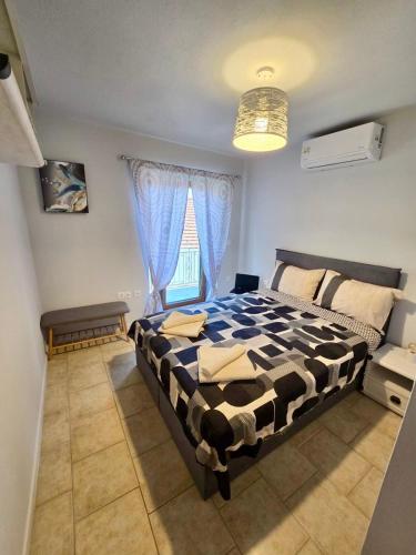 a bedroom with a black and white bed and a window at Daisy House Golden Beach Area in Potamia