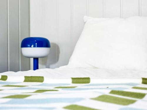 a bedroom with a white bed with a blue chair at W Ogrodzie Dla Gości in Sasino