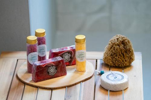 a wooden table with four bottles of soap and a hat at Elithos Villa in Vryses