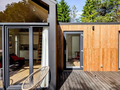 a house with sliding glass doors on a deck at W Ogrodzie Dla Gości in Sasino