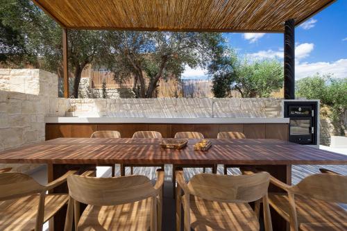 an outdoor dining room with a wooden table and chairs at Elithos Villa in Vryses