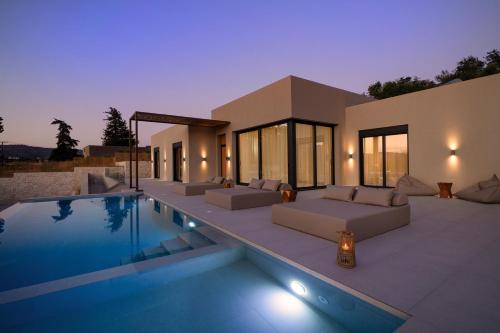 a villa with a swimming pool at night at Elithos Villa in Vryses