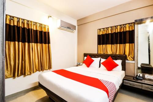 a bedroom with a large bed with red pillows at Hotel O Kuber Residency in Kolkata
