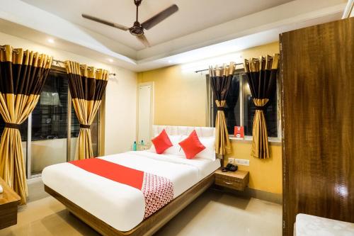 a bedroom with a bed with red pillows at Hotel O Kuber Residency in Kolkata