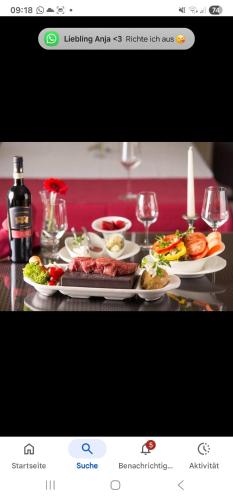 a table with plates of food and glasses of wine at Esmeralda Ferienwohnung Ebersbach-Musbach in Ebersbach-Musbach