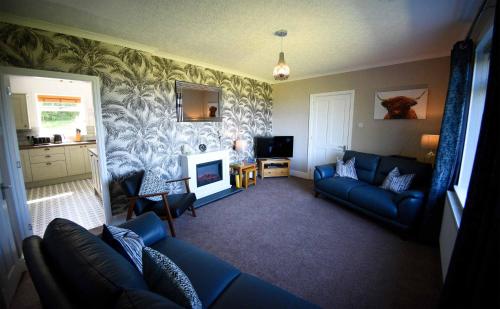 a living room with a couch and a fireplace at Fladda Chuain Holiday Home in Kilmuir