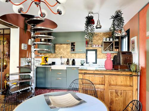 eine Küche mit blauen Schränken sowie einem Tisch und Stühlen in der Unterkunft Maison Poppins Cergy Island of Leisure Cergy Port in Cergy