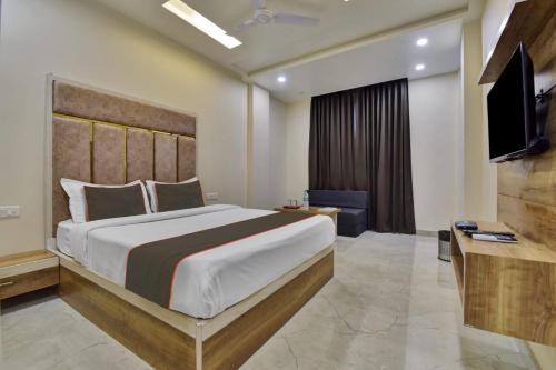 a bedroom with a large bed and a flat screen tv at Hotel Lakhdatar Palace in Jaipur
