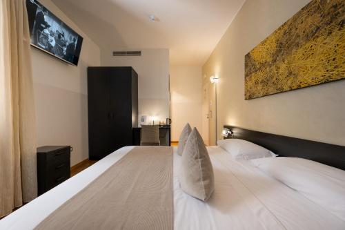 a bedroom with a large white bed with white pillows at Ca' Pozzo Inn in Venice