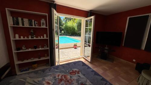 a living room with a door open to a pool at Chez Guy et Nath in Poussan