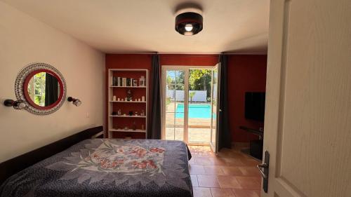 a bedroom with a bed and a view of a pool at Chez Guy et Nath in Poussan