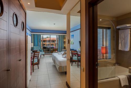 a hotel room with a bed and a bathroom at Pestana Porto Santo Premium All Inclusive Beach & SPA Resort in Porto Santo