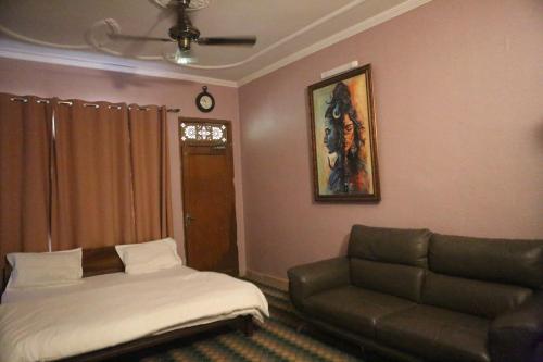 a living room with a couch and a couch and a bed at Vedic Dham Ganga in Rishīkesh