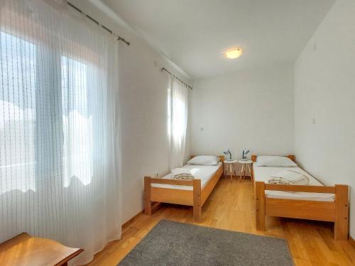 ニヴィーチェにあるApartment Martina by Interhomeのベッドが2つと窓のある部屋