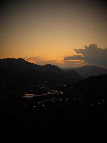 a sunset over a city with mountains in the background at 4 seasons. 4 სეზონი Glamping Georgia Racha in Ambrolauri