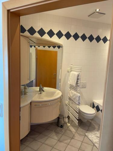 a bathroom with a sink and a toilet at Schmankerlwirt - Family Suite 