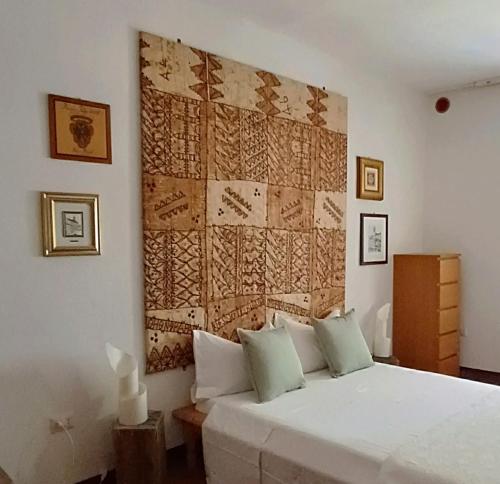 a bedroom with a white bed with a large wall at La Brocca di Valdichiascio in Gubbio