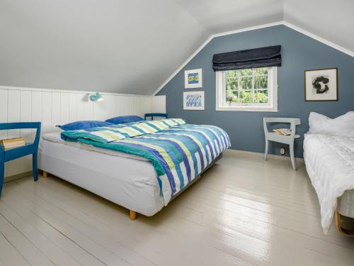 a blue bedroom with a bed and a window at Holiday Home Eseviki by Interhome in Balestrand