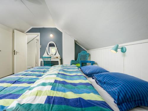 a bedroom with a bed and two blue chairs at Holiday Home Eseviki by Interhome in Balestrand
