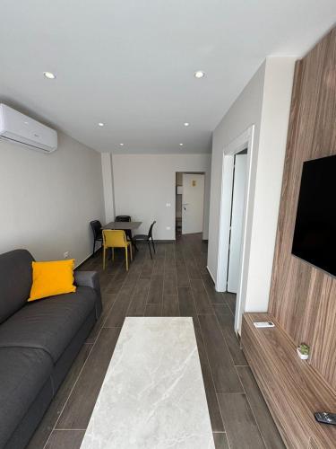 a living room with a couch and a flat screen tv at Sandy Vibes Apartments in Durrës