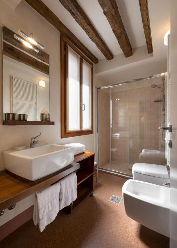 a bathroom with a tub and a sink and a shower at Ca' Pozzo Inn in Venice