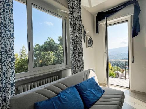 a living room with a couch and a large window at Holiday Home Villa Jose - PGI212 by Interhome in Civezza