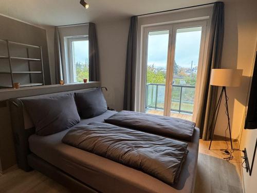 a bed in a room with a large window at Exklusives Wohnen im historischen Wasserturm dem Highlight von Delitzsch WE 213 in Delitzsch