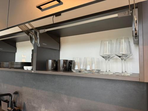 a row of wine glasses on a shelf in a kitchen at Exklusives Wohnen im historischen Wasserturm dem Highlight von Delitzsch WE 213 in Delitzsch