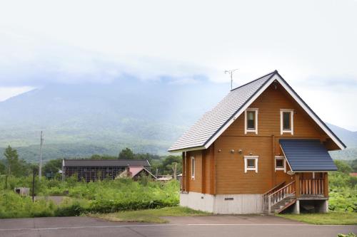 a large wooden house with a gambrel roof at パウダー小屋 in Kutchan