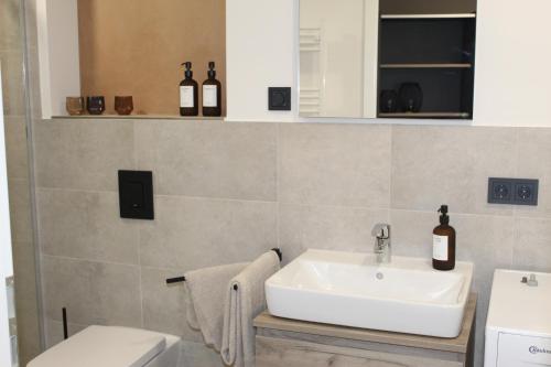 a bathroom with a white sink and a toilet at Exklusives Wohnen im historischen Wasserturm dem Highlight von Delitzsch WE 213 in Delitzsch