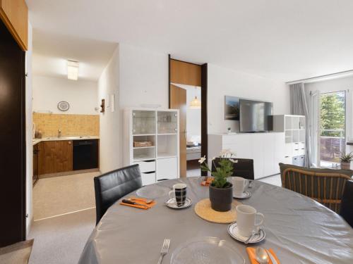 ダボスにあるApartment Allod Park Haus B 202 by Interhomeのテーブルと椅子のあるダイニングルームとキッチン