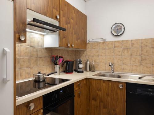 ダボスにあるApartment Allod Park Haus B 202 by Interhomeの木製のキャビネットとシンクを備えたキッチン