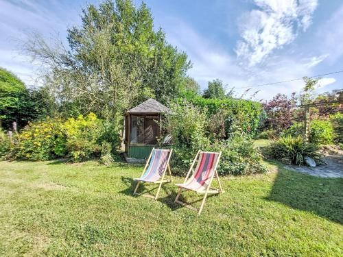 two lawn chairs sitting in a yard with a gazebo at Holiday Home Les Agapanthes by Interhome in Languenan