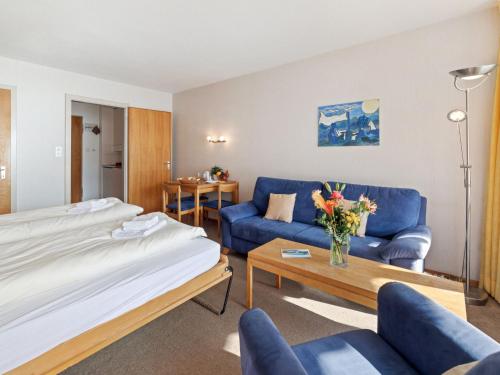 una habitación de hotel con una cama y un sofá en Apartment Promenade - Utoring-34 by Interhome, en Arosa