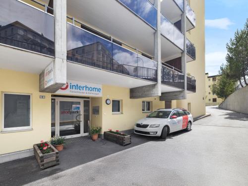 a car parked in a parking lot in front of a building at Apartment Allod Park Haus C U04 by Interhome in Davos